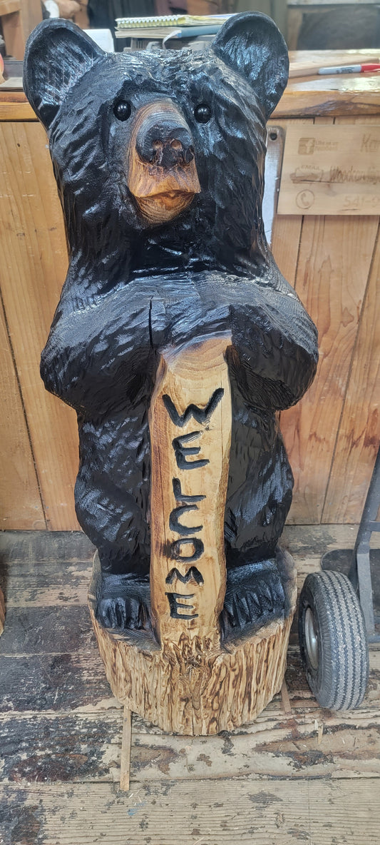 Black bear standing with welcome sign